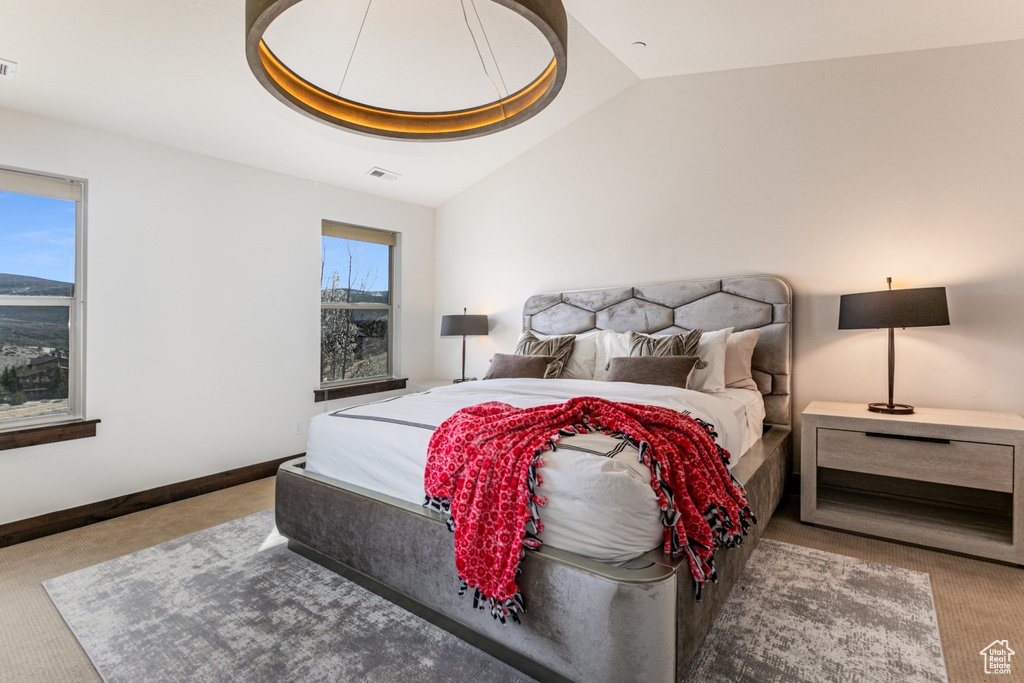 Bedroom featuring multiple windows, carpet flooring, and vaulted ceiling