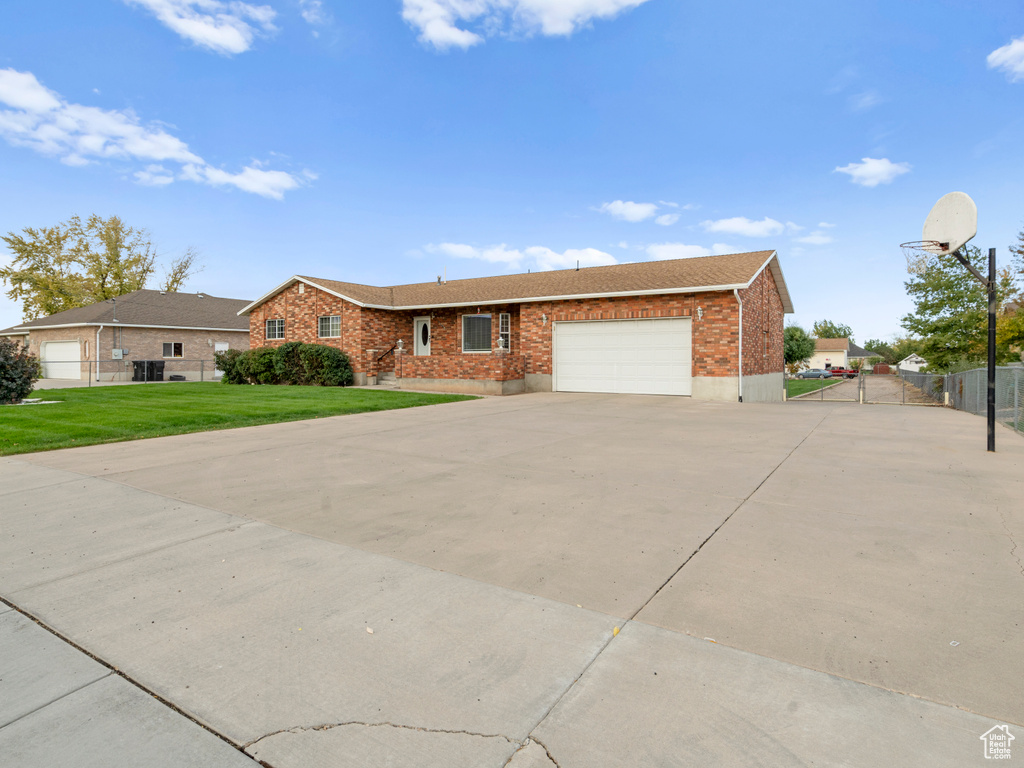 Ranch-style home with a garage and a front lawn