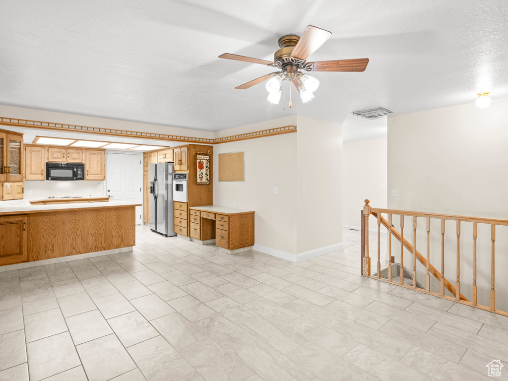 Unfurnished living room with a textured ceiling and ceiling fan