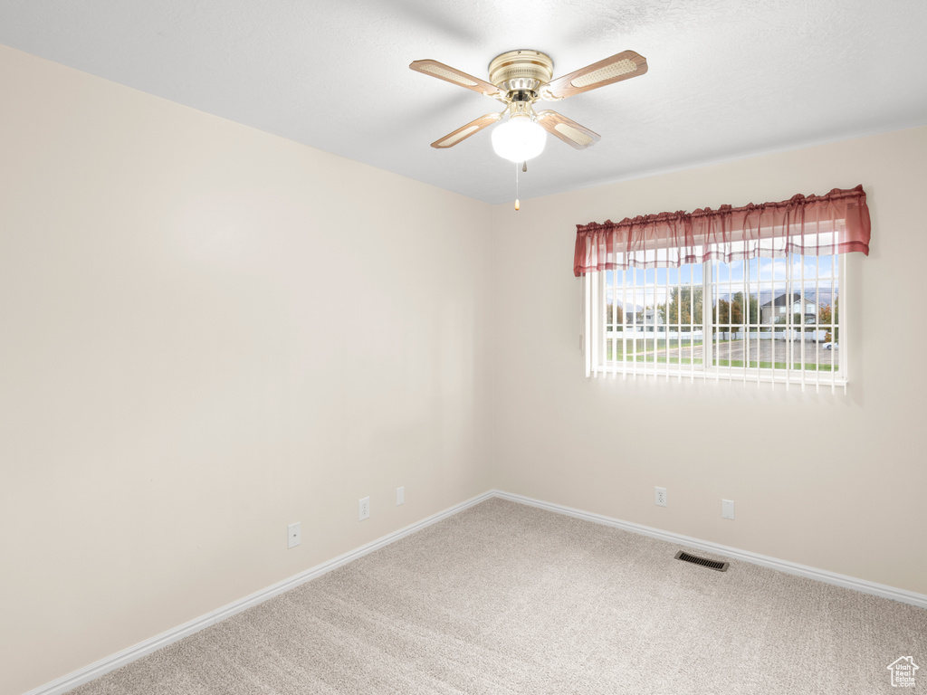 Empty room featuring carpet and ceiling fan