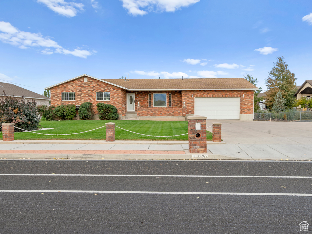 View of front of house with a front yard and a garage