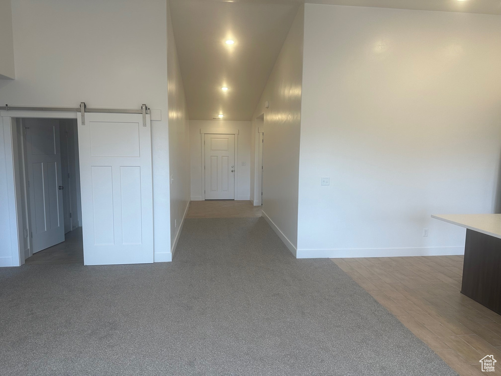 Unfurnished room with hardwood / wood-style floors and a barn door