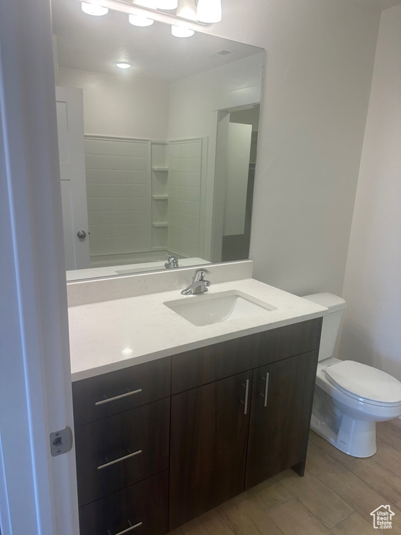 Bathroom with vanity, hardwood / wood-style flooring, and toilet