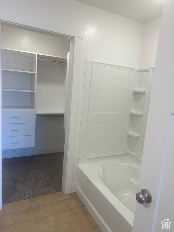 Bathroom with hardwood / wood-style flooring and tub / shower combination