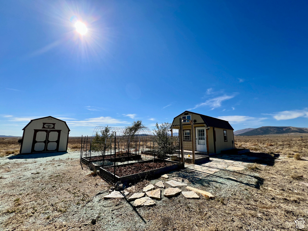 View of yard with a rural view, a shed, and a mountain view