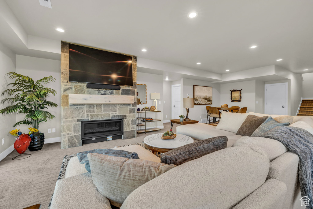 Carpeted living room featuring a stone fireplace