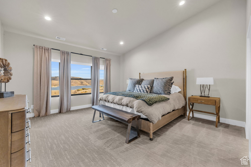 Carpeted bedroom featuring a water view and vaulted ceiling