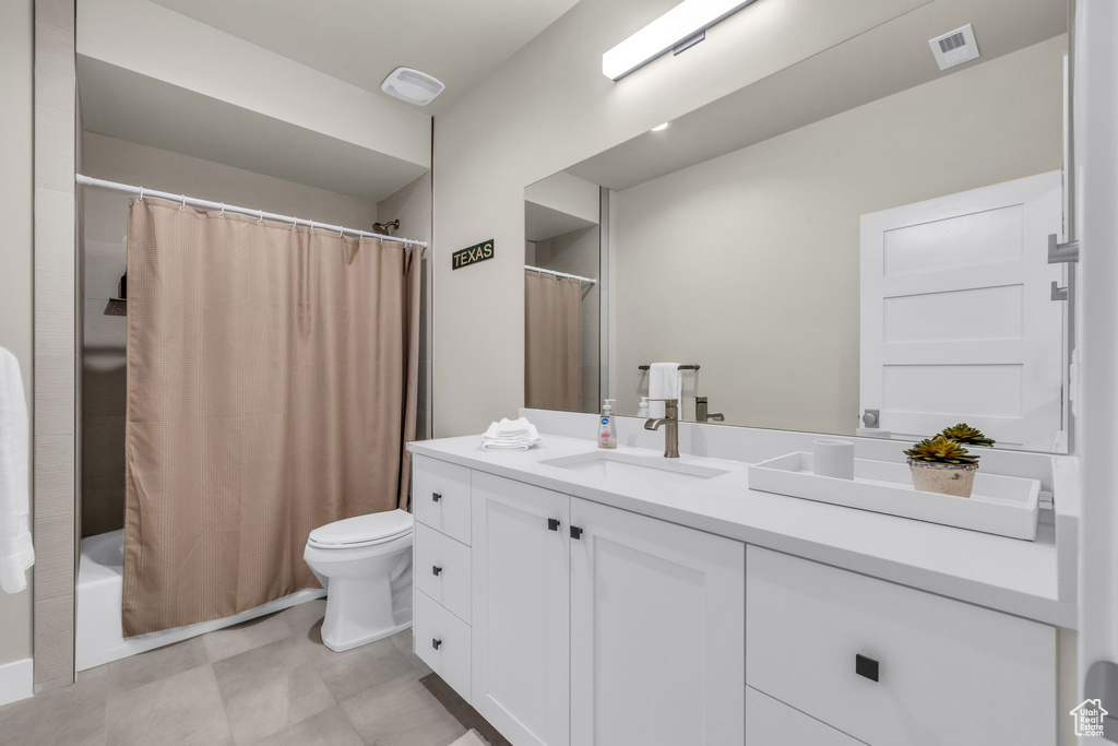 Full bathroom featuring vanity, shower / tub combo with curtain, and toilet