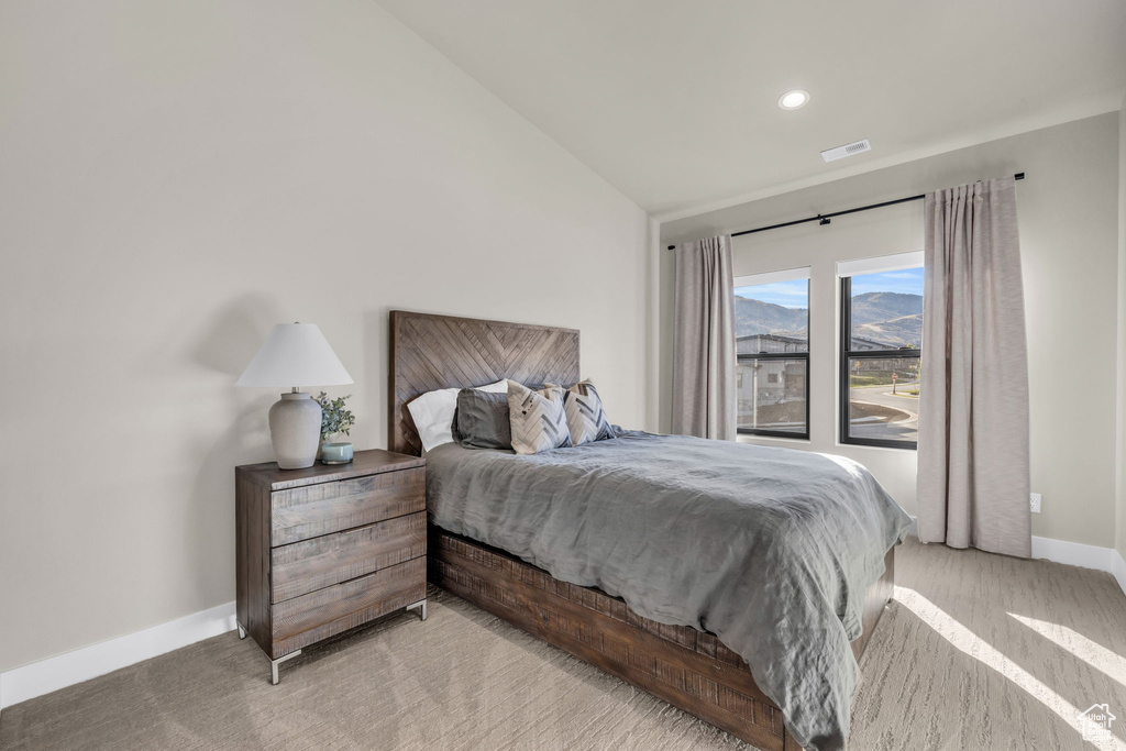 Bedroom with lofted ceiling and light colored carpet