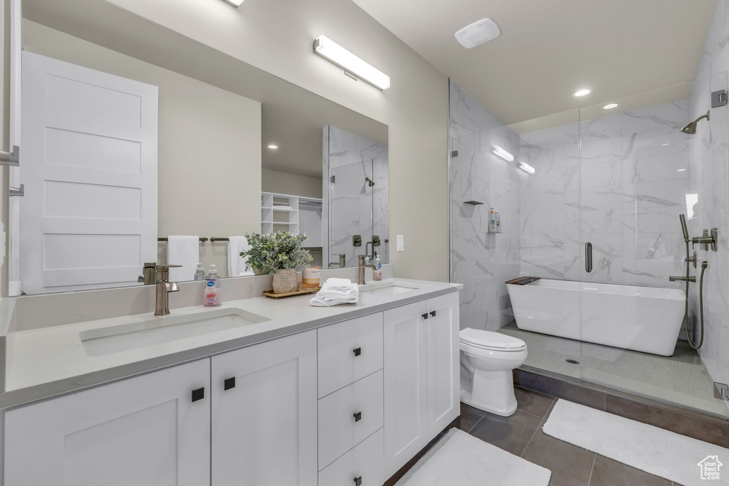 Full bathroom featuring vanity, shower with separate bathtub, toilet, and tile patterned floors