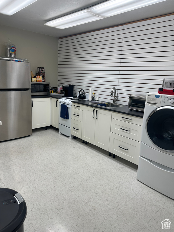 Kitchen with sink, white cabinets, stainless steel appliances, and washer / clothes dryer