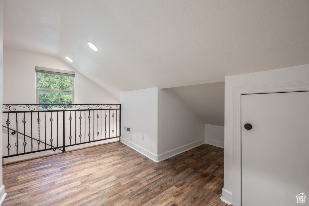 Additional living space featuring vaulted ceiling and dark hardwood / wood-style flooring