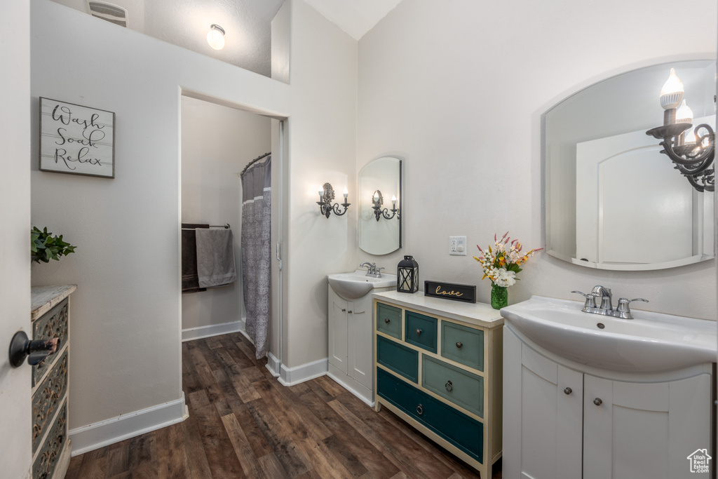 Bathroom with vanity, hardwood / wood-style flooring, and a towering ceiling