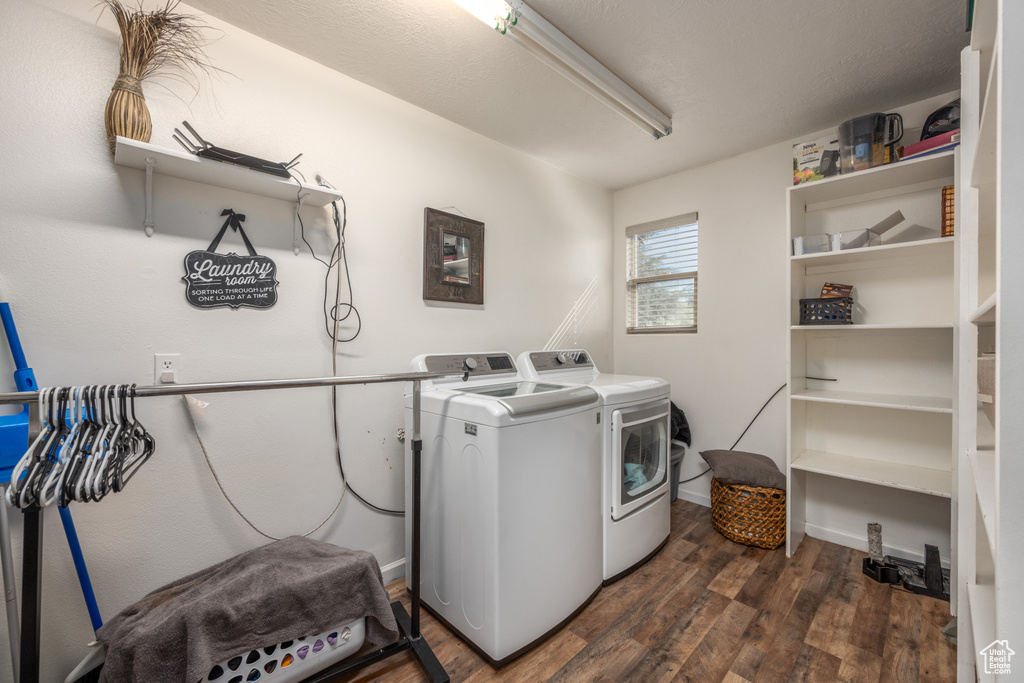 Washroom with dark wood-type flooring and washer and dryer