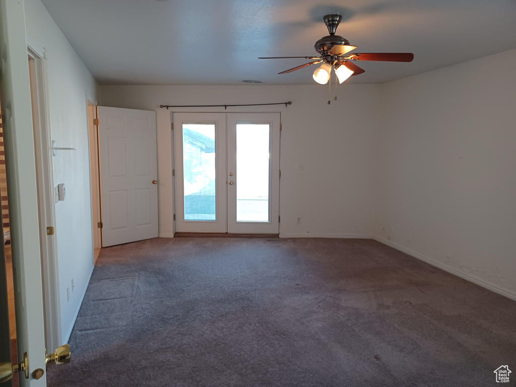 Carpeted spare room featuring french doors and ceiling fan