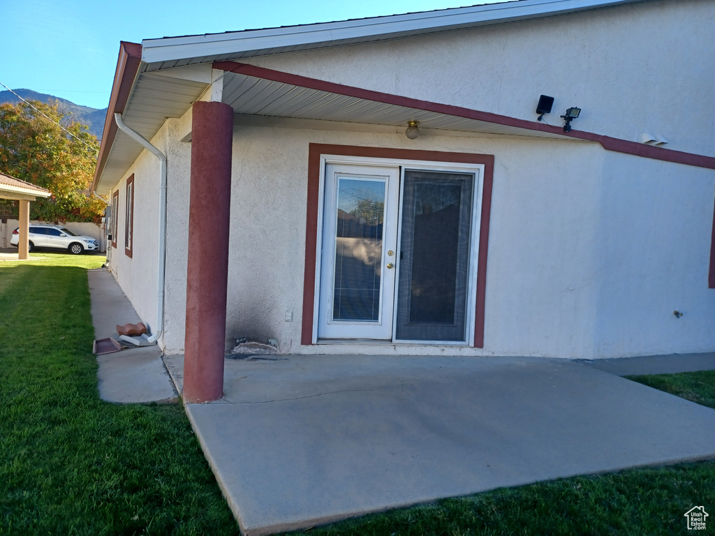 Exterior space with a yard, a patio area, and a mountain view