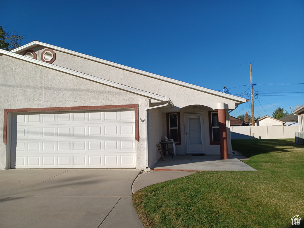 View of front of house with a front yard and a garage