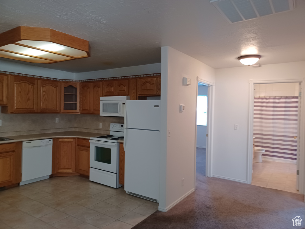 Kitchen featuring light tile patterned flooring and white appliances