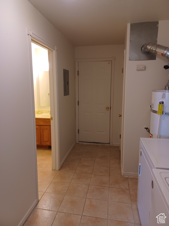 Laundry room with independent washer and dryer, secured water heater, electric panel, and light tile patterned flooring