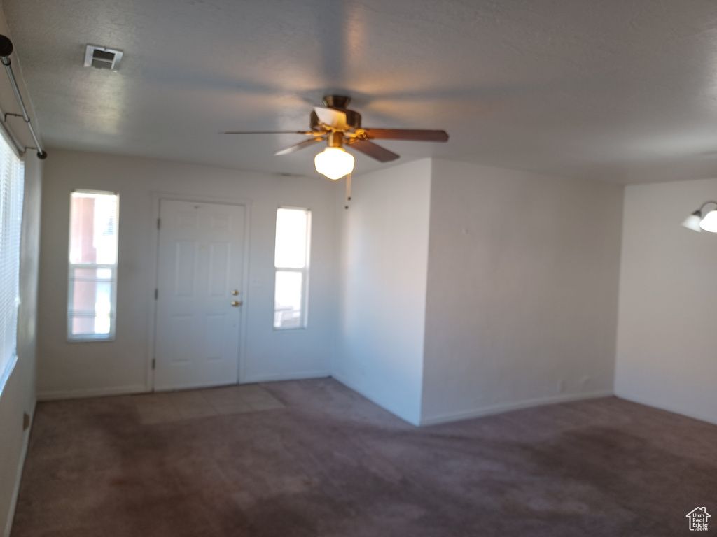 Carpeted entrance foyer featuring ceiling fan