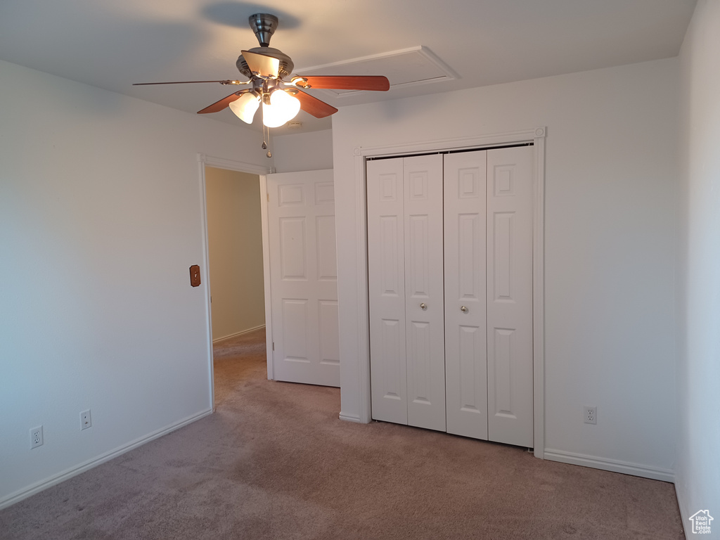 Unfurnished bedroom with a closet, ceiling fan, and light carpet