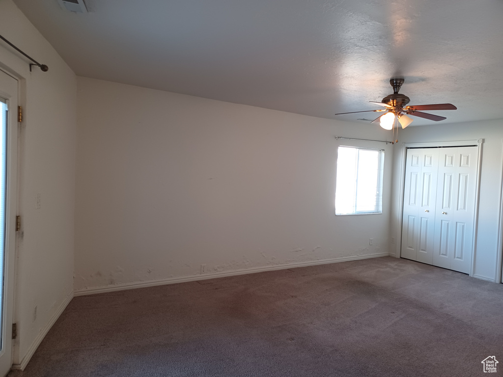 Empty room with carpet flooring and ceiling fan