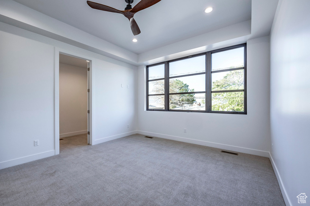 Unfurnished room featuring light colored carpet and ceiling fan