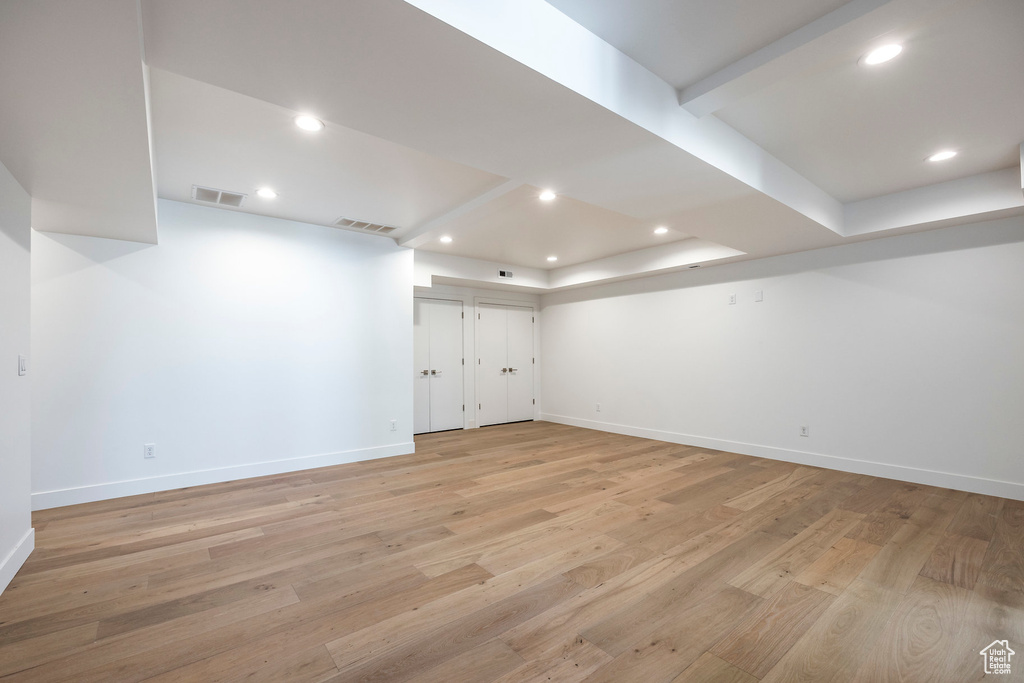 Basement with light hardwood / wood-style floors