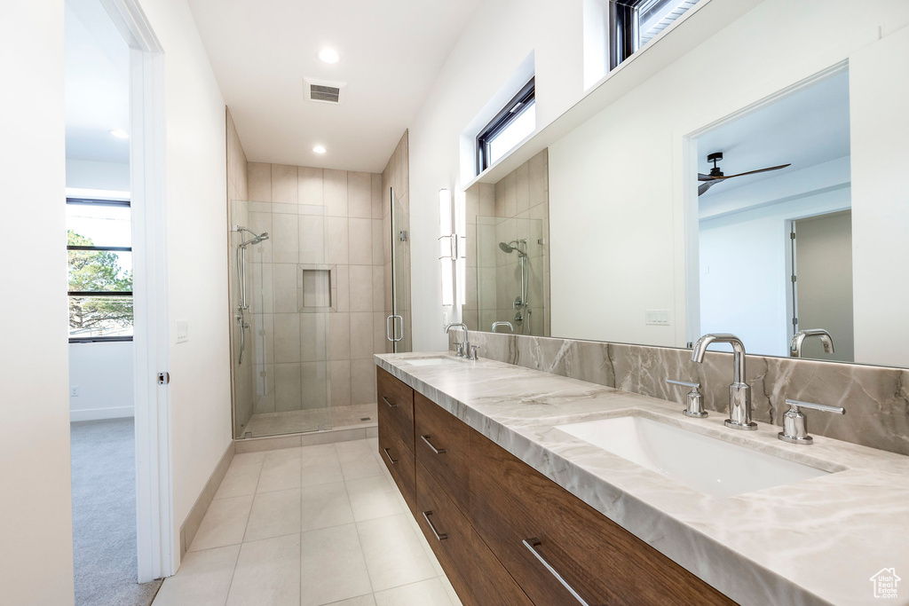 Bathroom featuring vanity, an enclosed shower, a healthy amount of sunlight, and tile patterned floors