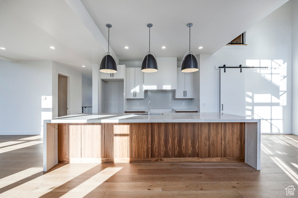 Kitchen with a large island, white cabinetry, and a barn door