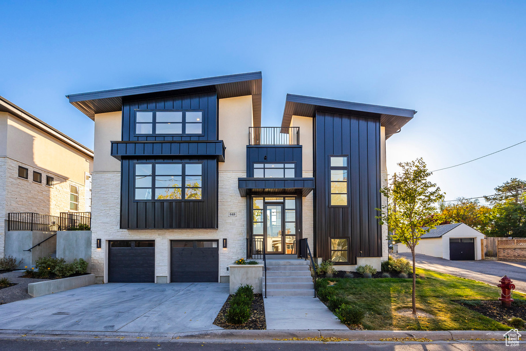 Contemporary home featuring a balcony and a garage