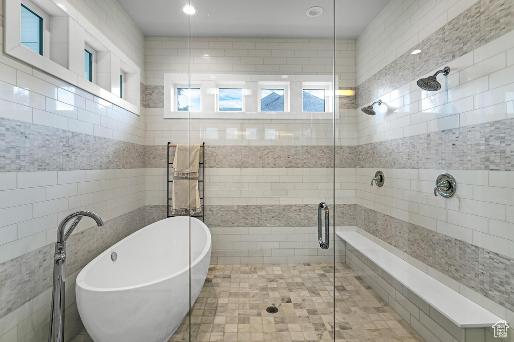 Bathroom featuring plus walk in shower and tile walls