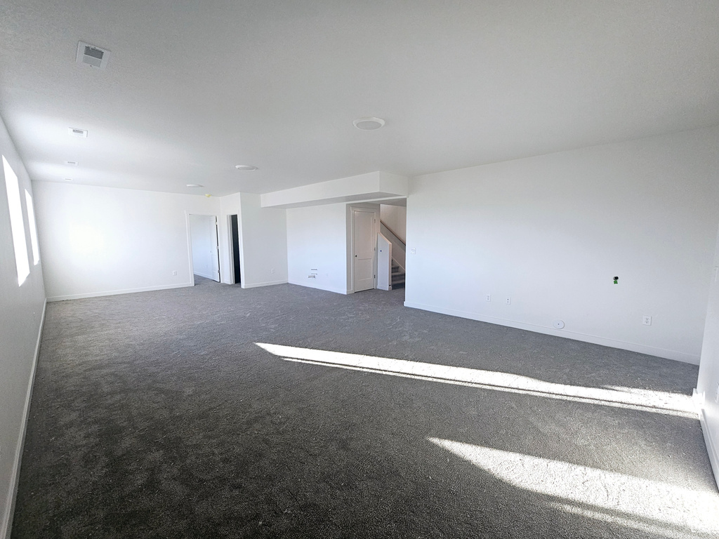 Unfurnished room featuring dark carpet