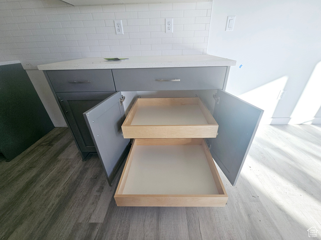 Room details featuring tasteful backsplash and wood-type flooring