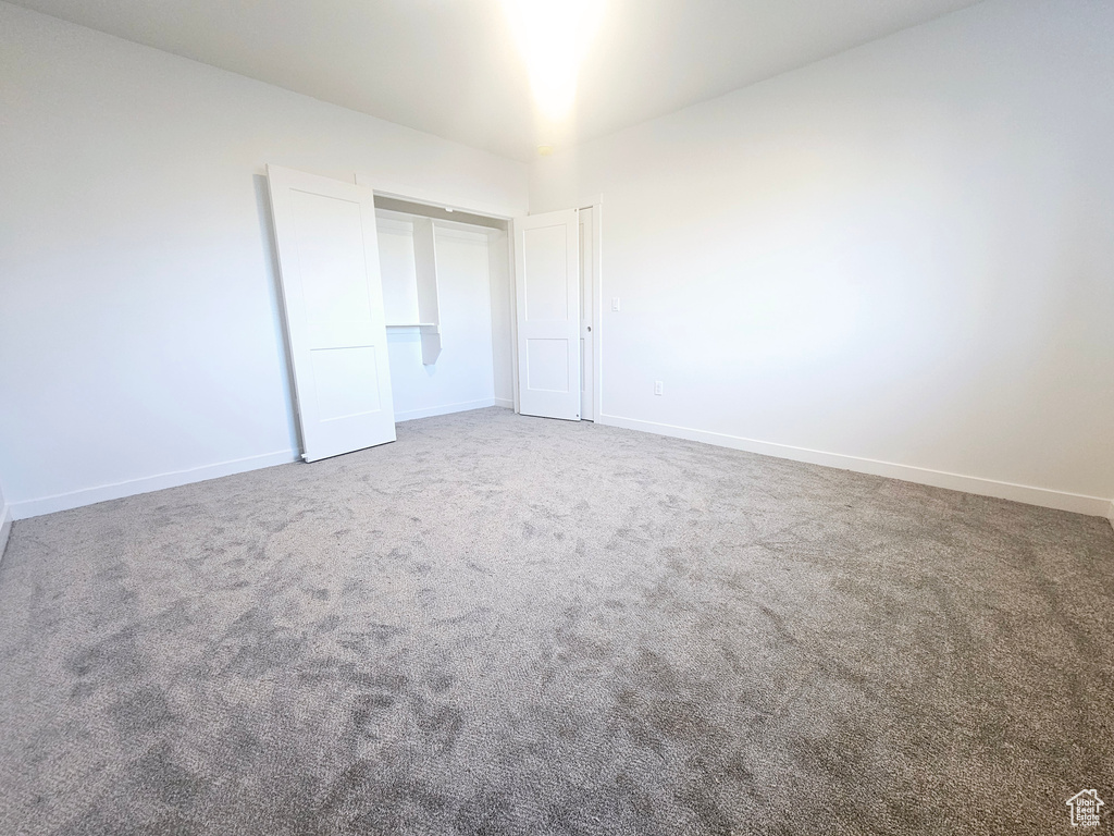 Unfurnished bedroom featuring carpet and a closet