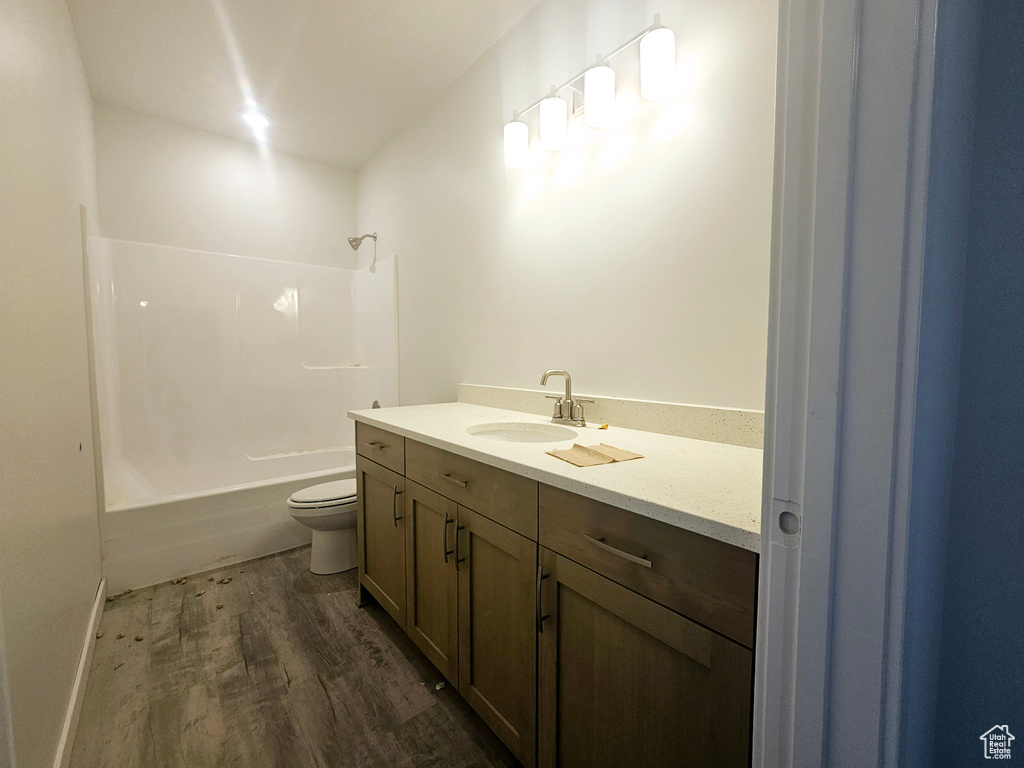 Full bathroom featuring vanity, wood-type flooring, toilet, and shower / bath combination