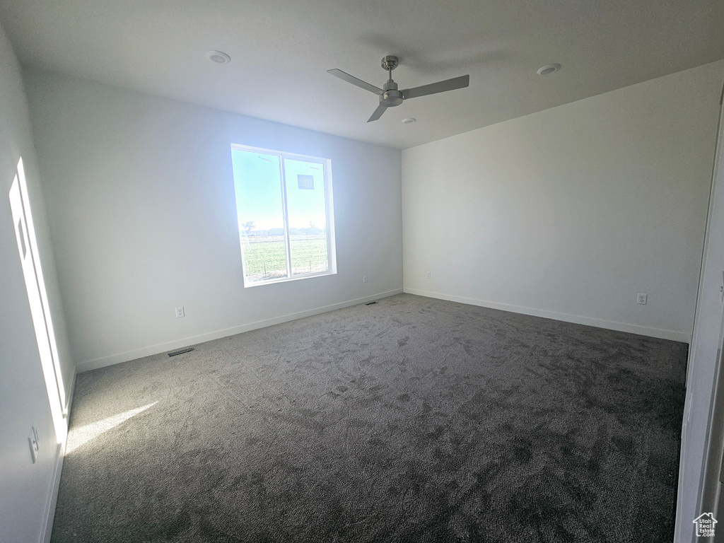 Carpeted spare room with ceiling fan