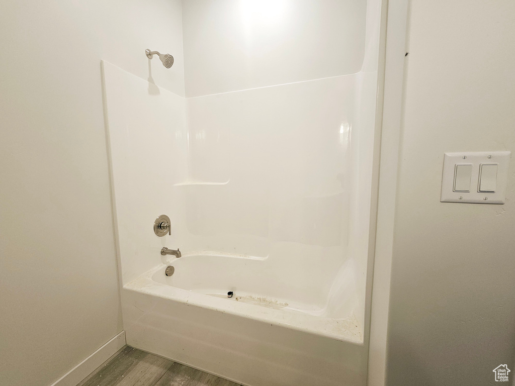 Bathroom with shower / bathing tub combination and hardwood / wood-style flooring