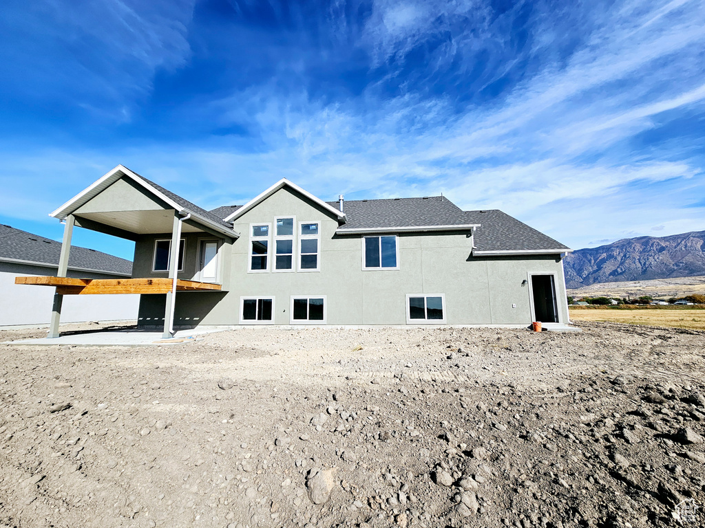 Back of property with a mountain view and a balcony