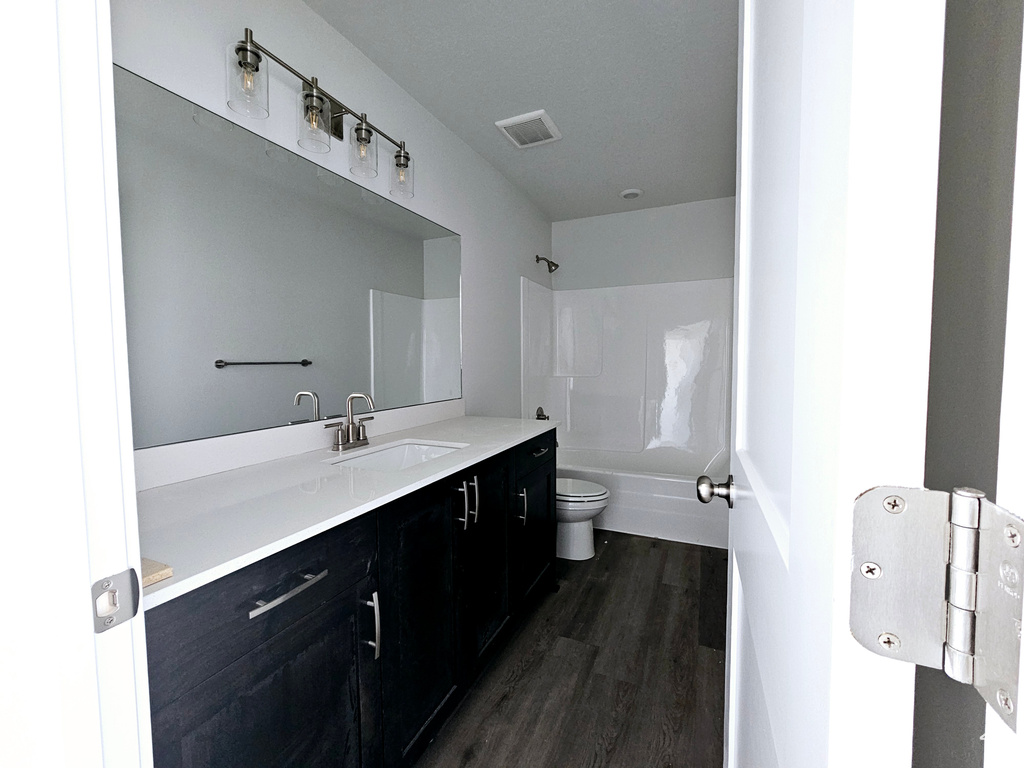 Full bathroom with toilet, hardwood / wood-style flooring, vanity, and shower / bathtub combination