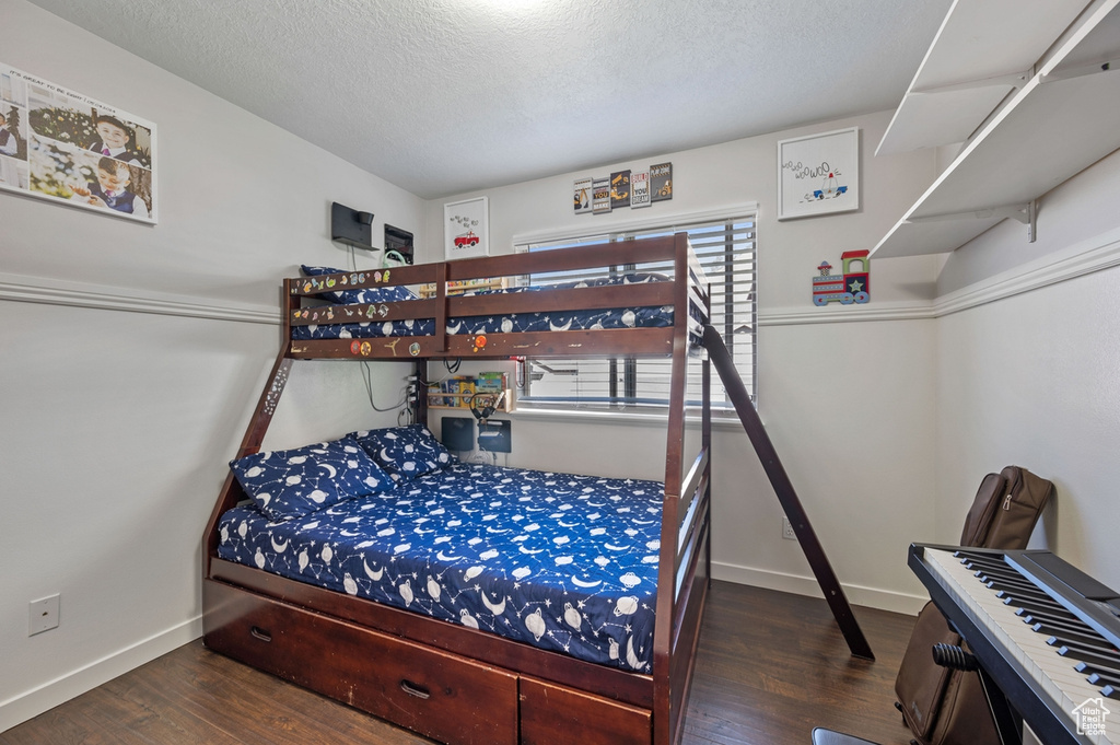 Bedroom featuring a textured ceiling and dark wood-type flooring