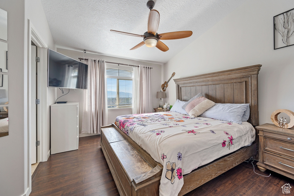 Bedroom featuring ceiling fan, a textured ceiling, and dark hardwood / wood-style flooring