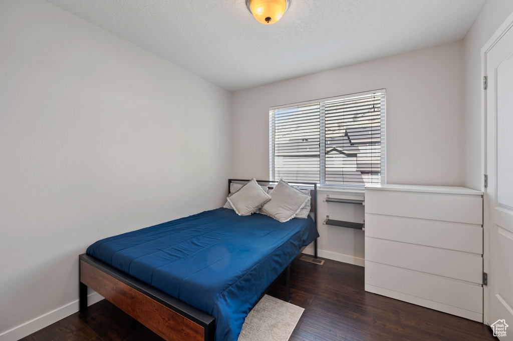 Bedroom featuring a textured ceiling and dark hardwood / wood-style floors