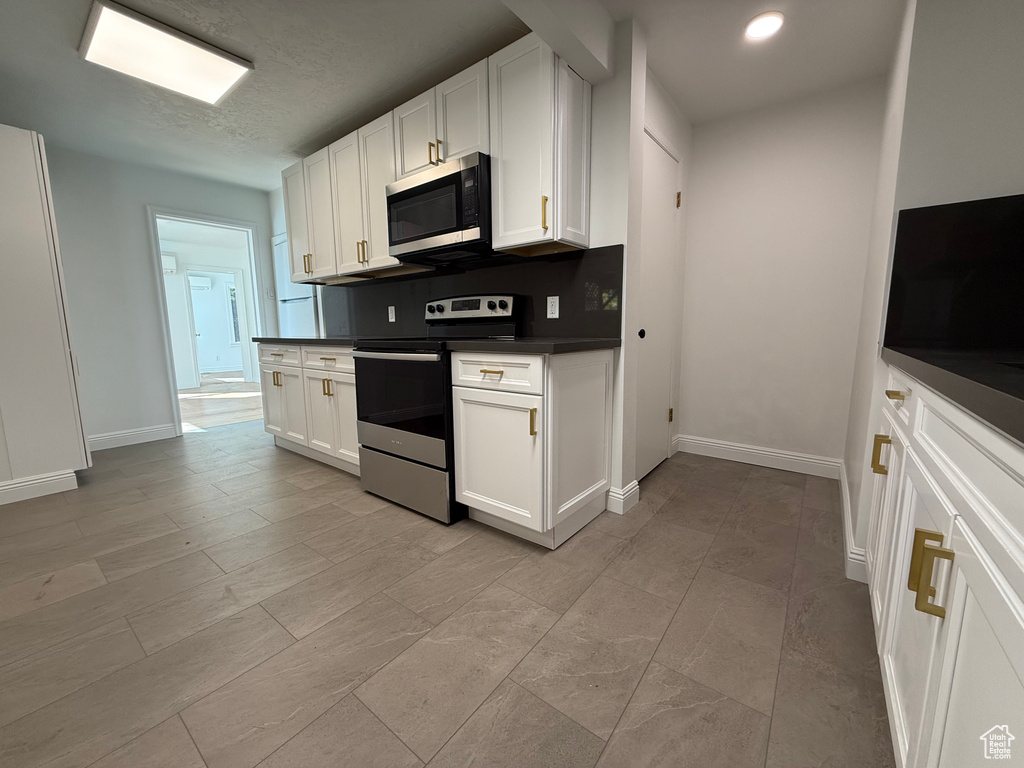 Kitchen with white cabinetry, appliances with stainless steel finishes, and a textured ceiling