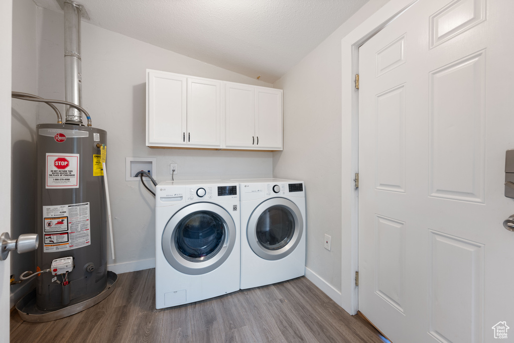 Laundry room featuring cabinets, light hardwood / wood-style flooring, independent washer and dryer, and gas water heater