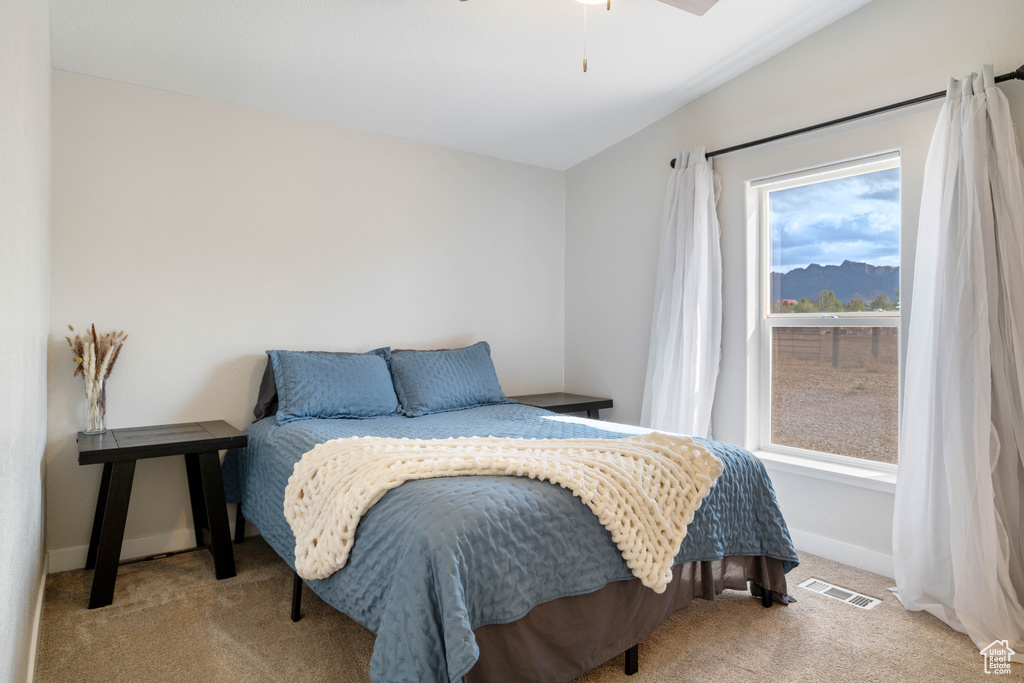 Bedroom featuring lofted ceiling, light colored carpet, and ceiling fan