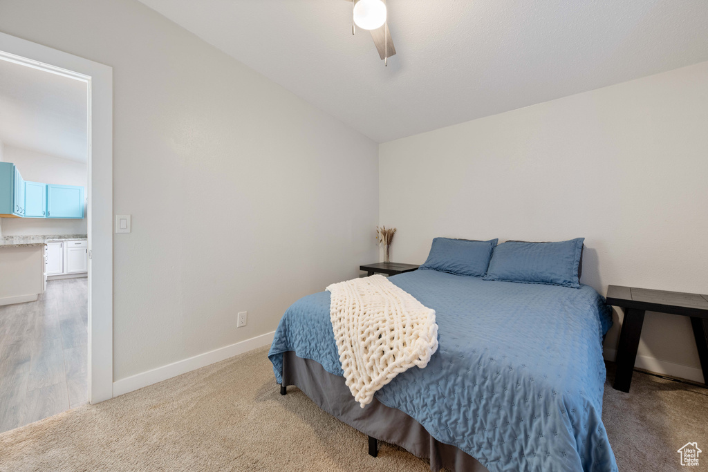 Bedroom featuring ceiling fan, lofted ceiling, and light colored carpet