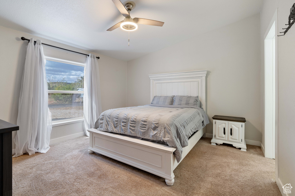 Carpeted bedroom with vaulted ceiling and ceiling fan