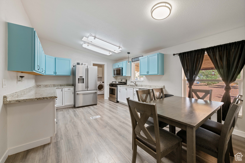 Dining area with washer / dryer, light hardwood / wood-style flooring, a textured ceiling, and sink