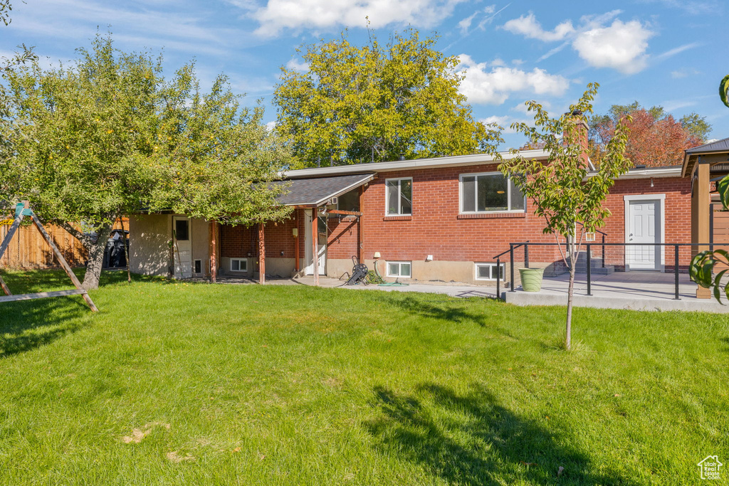 Back of house with a patio and a yard